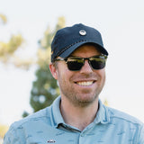 man smiling wearing black porter lite sundaze hat by sunday golf 