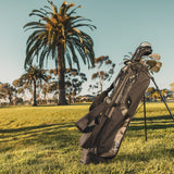 matte black El Camino golf bag by Sunday Golf on golf course with palm trees in background 